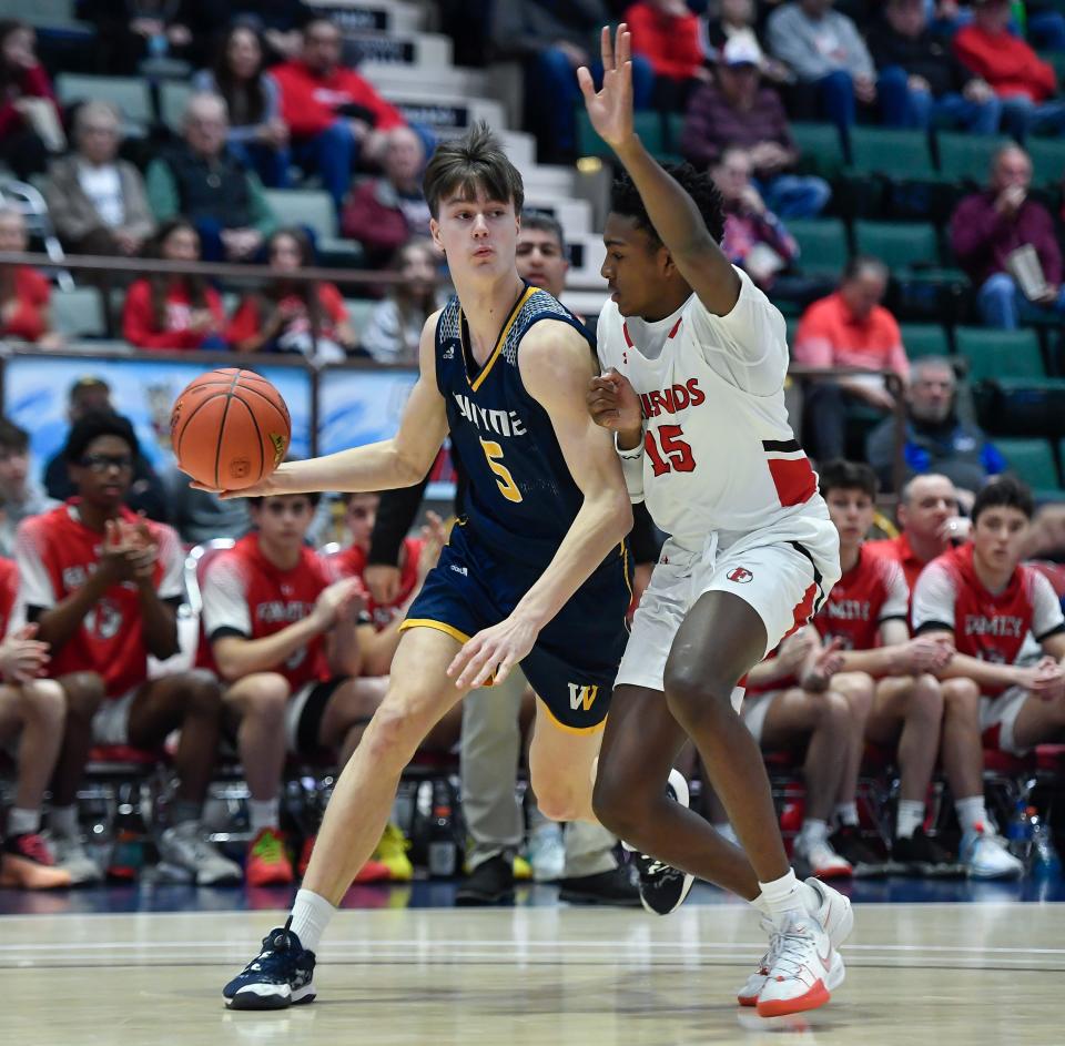 Wayne's Cam Blankenberg, left, is defended by Friends Academy's Joshua McKenzie during a NYSPHSAA Class A Boys Basketball Championships semifinal in Glens Falls, N.Y., Friday, March 15, 2024. Wayne advanced to the Class A final with a 61-48 win over Friends Academy-VIII.