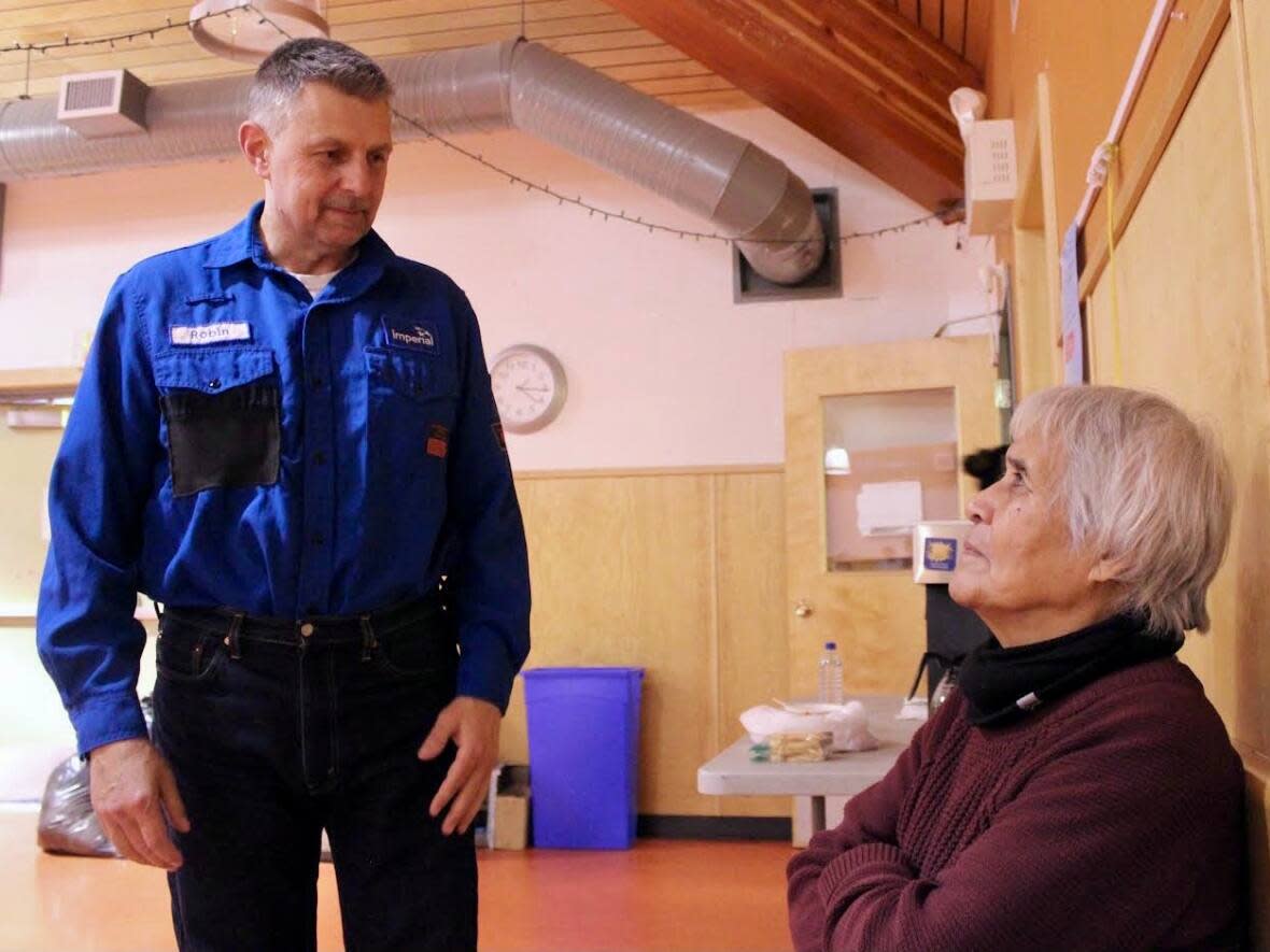 Robin McNaught, an operations foreman with Imperial Oil in Norman Wells, N.W.T., speaks with Lucy Jackson, the chief in Fort Good Hope, N.W.T. The company visited Fort Good Hope on Tuesday as part of 'neighbour week,' a tour to all 5 Sahtu communities.   (Liny Lamberink/CBC - image credit)