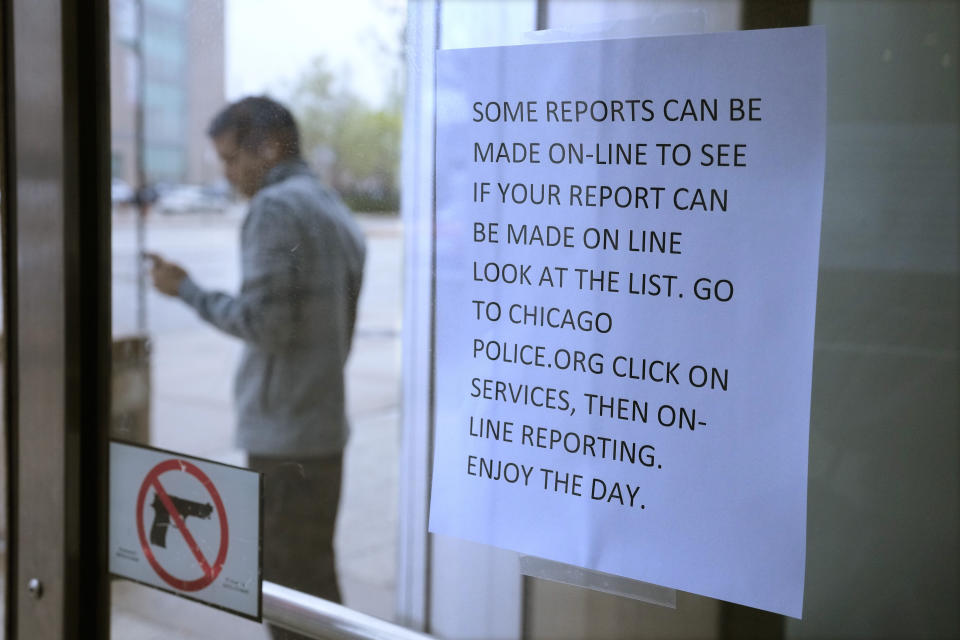 FILE - A migrant from Venezuela talks outside on a cell phone where he has taken shelter with others in the Chicago Police Department's 16th District station on Monday, May 1, 2023. In Chicago, where 13,000 migrants have settled in the last year, Mayor Brandon Johnson and Illinois Gov. J.B. Pritzker wrote Homeland Security Secretary Alejandro Mayorkas to ask for parole for asylum-seekers, which, they say, would allow him to get around the wait for a work permit. (AP Photo/Charles Rex Arbogast, File)