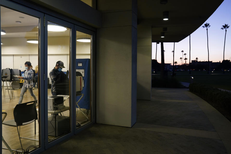 FILE - In this Nov. 3, 2020, file photo, voters cast their ballots at a polling place in Newport Beach, Calif. It will cost California counties an estimated $215 million to stage an expected recall election this year that could oust Democratic Gov. Gavin Newsom from office. (AP Photo/Ashley Landis, File)