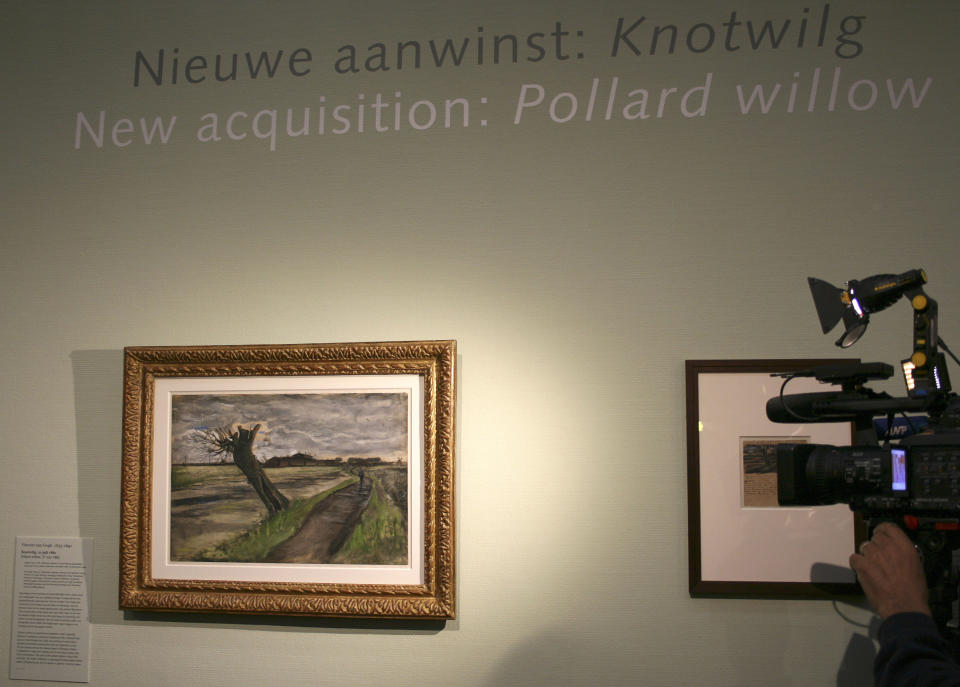 A cameraman films an 1882 water color of a pollard willow by Vincent van Gogh at the Van Gogh Museum in Amsterdam, Netherlands, Thursday May 10, 2012. The Van Gogh Museum unveiled the painting Thursday, the first addition in five years to its world-famous collection of works by the post-impressionist.  (AP Photo/Mike Corder)