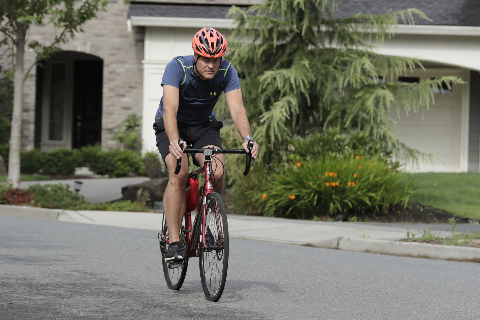 Neal Browning, the second person to receive a trial dose of a COVID-19 vaccine, rides his bike, Friday, July 24, 2020, in Bothell, Wash. As the world's biggest COVID-19 vaccine study gets underway more than four months after Browning and 44 others became the first participants in a phase-one coronavirus vaccine study that has produced encouraging results, more than 150,000 Americans have filled out an online registry in recent weeks signaling interest to volunteer for other studies, according to a virologist with the Fred Hutchinson Cancer Research Institute in Seattle. (AP Photo/Ted S. Warren)