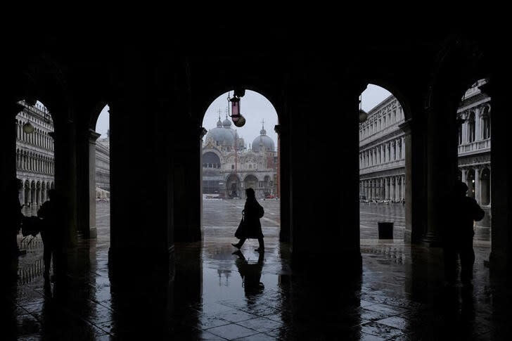 Varias personas pasan por la Plaza de San Marcos durante un evento excepcional de marea alta frenada por el sistema de barreras Mose en Venecia, Italia.