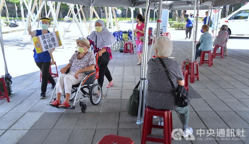 圖為民眾19日到台北市網球中心施打疫苗，在相關工作人員引導下依指標入場。（中央社）