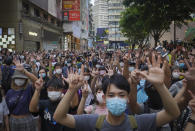 FILE - In this Wednesday, July. 1, 2020 file photo, protesters against the new national security law gesture with five fingers, signifying the "Five demands - not one less" on the anniversary of Hong Kong's handover to China from Britain in Hong Kong. Only five years ago, former British Prime Minister David Cameron was celebrating a “golden era” in U.K.-China relations, bonding with President Xi Jinping over a pint of beer at the pub and signing off trade deals worth billions. Those friendly scenes now seem like a distant memory, with hostile rhetoric ratcheting up this week over Beijing’s new national security law on Hong Kong. China has threatened “consequences” after Britain offered refuge to millions in the former colony. (AP Photo/Vincent Yu, file)