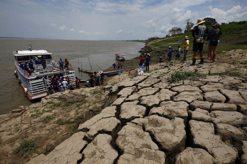 Les habitants d'une communauté riveraine transportent de la nourriture et de l'eau potable, après reçu de l'aide, en raison de la sécheresse à Careiro da Varzea