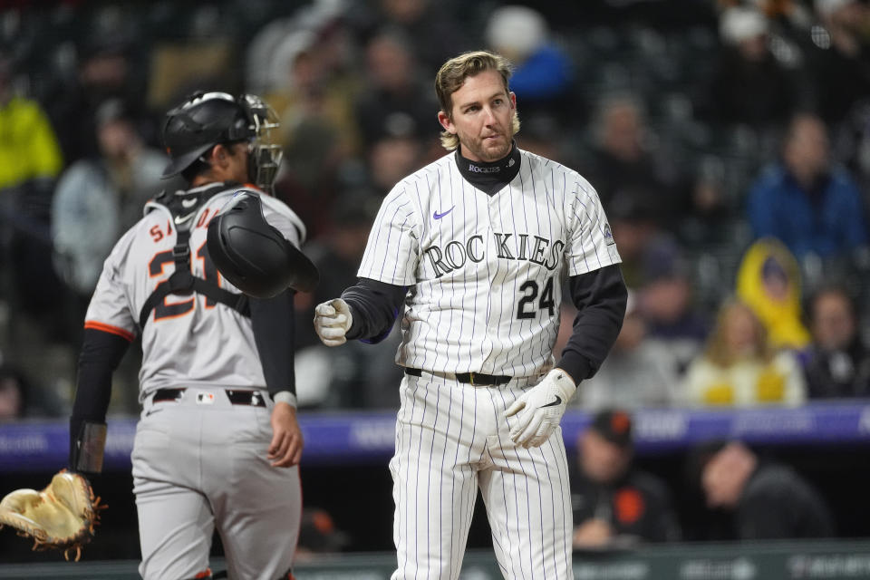 Colorado Rockies' Ryan McMahon, front, tosses his helmet after striking out against San Francisco Giants relief pitcher Ryan Walker to end the eighth inning of a baseball game Tuesday, May 7, 2024, in Denver. (AP Photo/David Zalubowski)