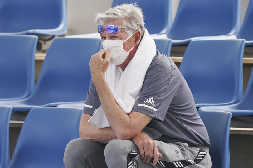A spectator wears a mask as smoke haze shrouds Melbourne during an Australian Open practice session at Melbourne Park in Australia, Tuesday, Jan. 14, 2020. Smoke haze and poor air quality caused by wildfires temporarily suspended practice sessions for the Australian Open at Melbourne Park on Tuesday, but qualifying began later in the morning in "very poor" conditions and amid complaints by at least one player who was forced to forfeit her match. (Michael Dodge/AAP Image via AP)