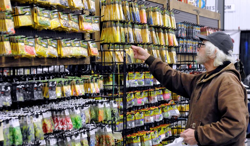 Tom Gosiewski picks out a new lure for future fishing trips during his Thursday visit to the Northeast Ohio Sportsman Show in Mount Hope. The show continues today and Saturday.