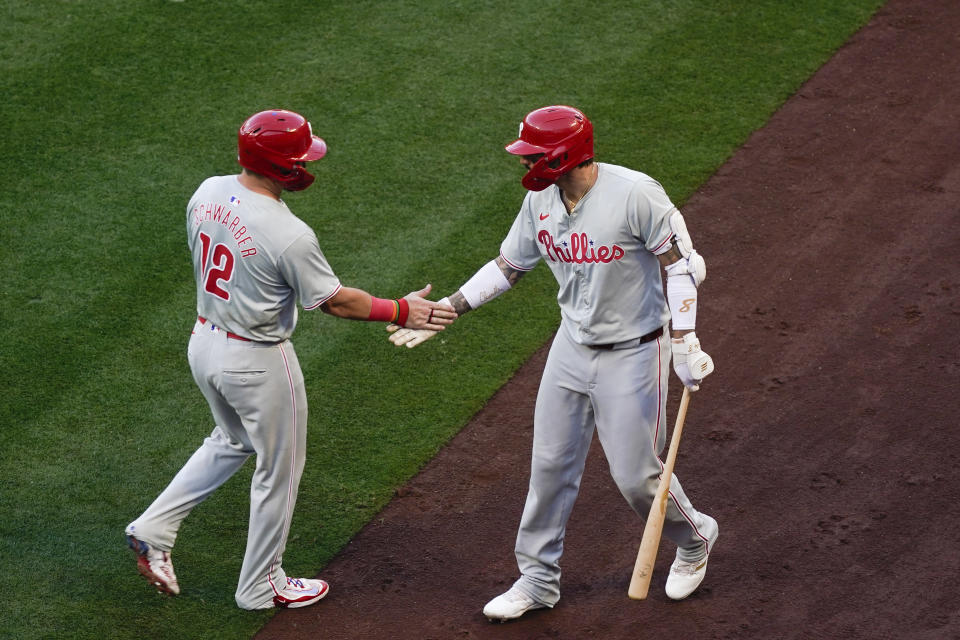 Philadelphia Phillies designated hitter Kyle Schwarber, left, celebrates with Nick Castellanos, right, after scoring off a single hit by Alec Bohm during the first inning of a baseball game against the Los Angeles Angels, Monday, April 29, 2024, in Anaheim, Calif. (AP Photo/Ryan Sun)