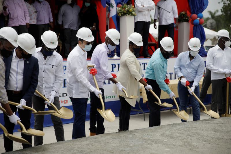 Haiti's President Jovenel Moise uses a shovel during the launch ceremony of a project to strengthen electricity networks in Haiti, in Port-au-Prince