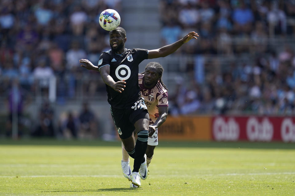 Minnesota United defender Kemar Lawrence (92) reaches for the ball against Portland Timbers forward Yimmi Chará (23) during the second half of an MLS soccer match at Allianz Field in Saint Paul, Minn., Saturday, July 30, 2022. (AP Photo/Abbie Parr)