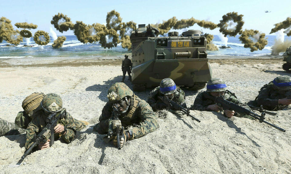 FILE - In this March 12, 2016, file photo, Marines of the U.S., left, and South Korea, wearing blue headbands on their helmets, take positions after landing on a beach during the joint military combined amphibious exercise, called Ssangyong, part of the Key Resolve and Foal Eagle military exercises, in Pohang, South Korea. South Korea and the U.S. say they've decided to end their springtime military drills to back diplomacy with North Korea. (Kim Jun-bum/Yonhap via AP, File)