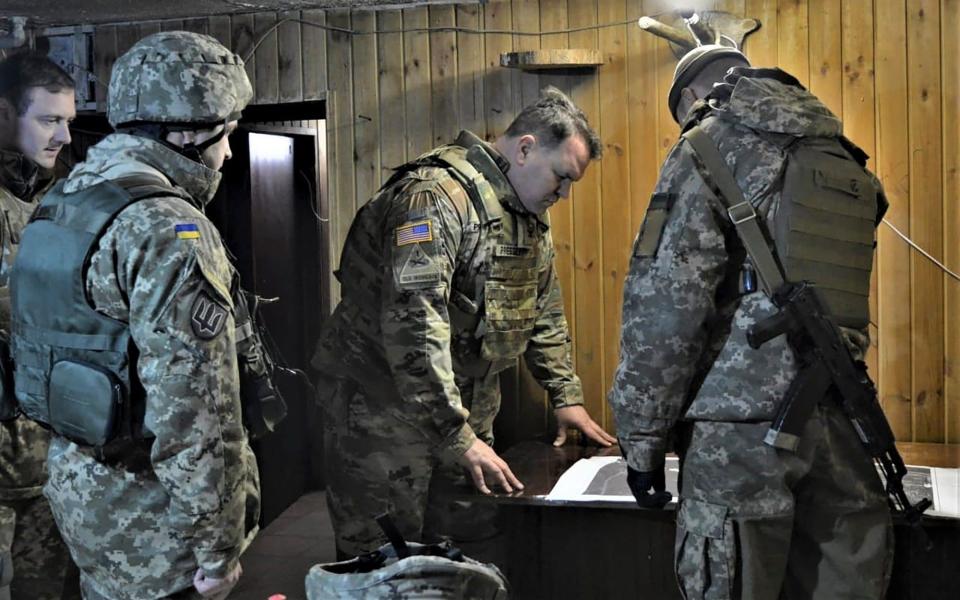 Attache of the Land Forces at the US Embassy in Ukraine Colonel Brandon Presley looks at the map during the visit by a delegation of the US Embassy in Ukraine to the Joint Forces operation area in the war-hit Donetsk region, Ukraine - AP