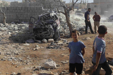 Residents inspect a damaged site in what activists say was a U.S. strike, in Kfredrian, Idlib province September 23, 2014. REUTERS/Abdalghne Karoof