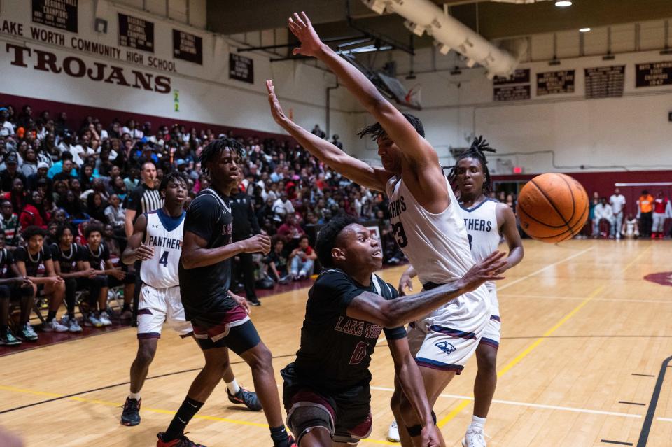 Lake Worth guard Calvin Sirmans (0) makes a pass under pressure from Dwyer's Blake Wilson (23) during the second half of the game between Dwyer and host Lake Worth on Tuesday, January 31, 2023, in Lake Worth Beach, FL. Final score, Lake Worth, 62, Dwyer, 57.