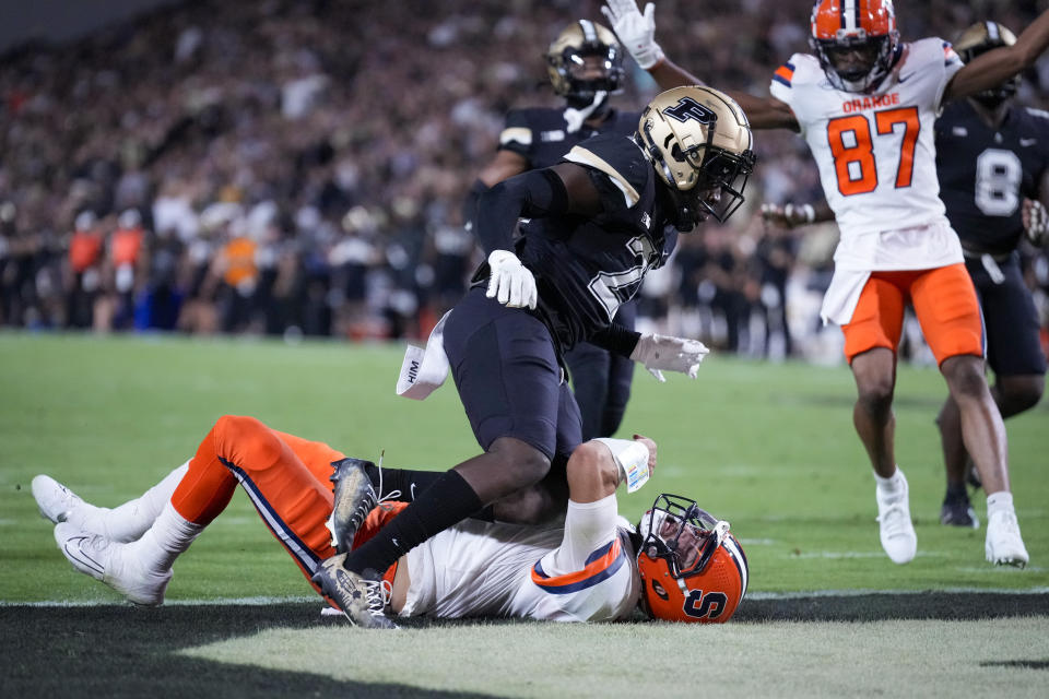 Syracuse quarterback Garrett Shrader, on ground, scores a touchdown under Purdue defensive back Sanoussi Kane during the first half of an NCAA college football game in West Lafayette, Ind., Saturday, Sept. 16, 2023.(AP Photo/AJ Mast)