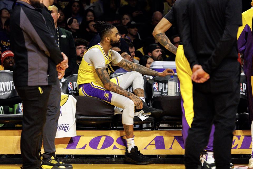 Lakers guard D'Angelo Russell sits lounges on the bench in the final moments of the Lakers' loss to the Nuggets