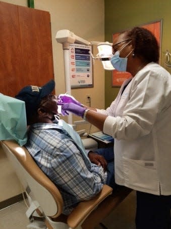 Dr. Valerie Washington of Affordable Dentures & Implants located (left) provided free dental care as a special thank you to Air Force veteran Gilbert Haynes, 70, for his Military service. The dental care included a tooth extraction and new upper and lower dentures to restore Gilbert’s smile.