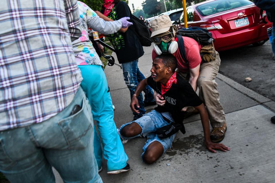 A protestor is assisted by medic protestors after being hit by tear gas near the 5th police precinct during a demonstration to call for justice for George Floyd, a Black man who died while in custody of the Minneapolis police, on May 30, 2020 in Minneapolis, Minnesota. (Photo by CHANDAN KHANNA/AFP via Getty Images) (Photo: CHANDAN KHANNA via Getty Images)