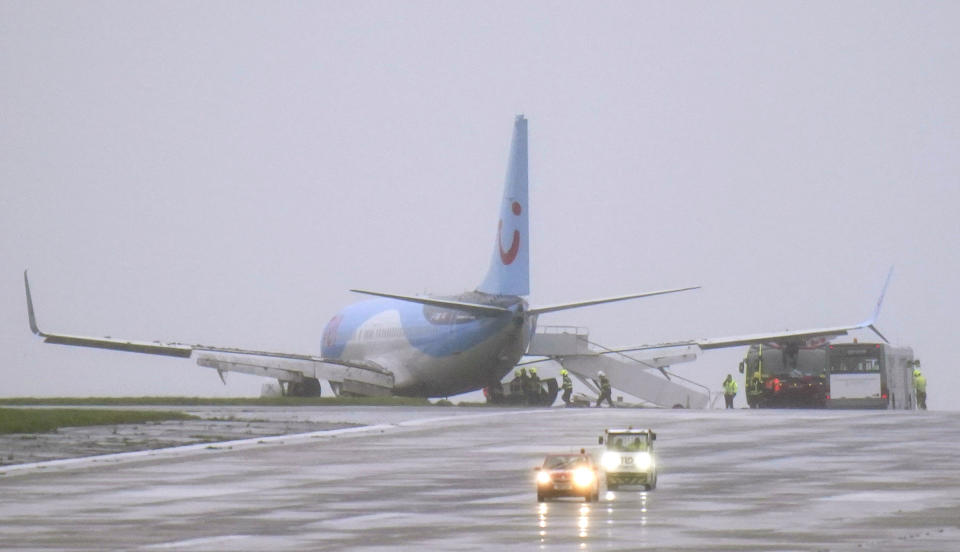 Emergency services next to a passenger plane which came off the runway while landing in windy conditions at Leeds Bradford Airport, Leeds, England, Friday, Oct. 20, 2023. (Danny Lawson/PA via AP)