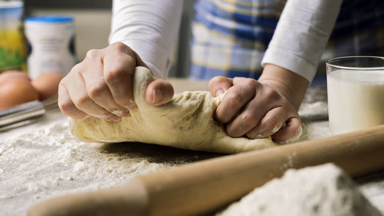 Hands kneading pizza dough