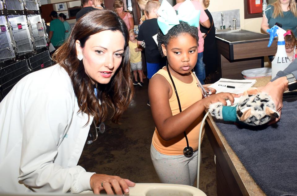 Dr. Morgan McDaniel, veterinarian and owner of Montgomery Animal Hospital + Hotel, shows Trinity Frances, 7, her stuffed white leopard's heart on the ultrasound machine as Trinity holds the probe. On Saturday, the clinic invited children to "Future Vet Day"  where they learned about being a veterinarian.