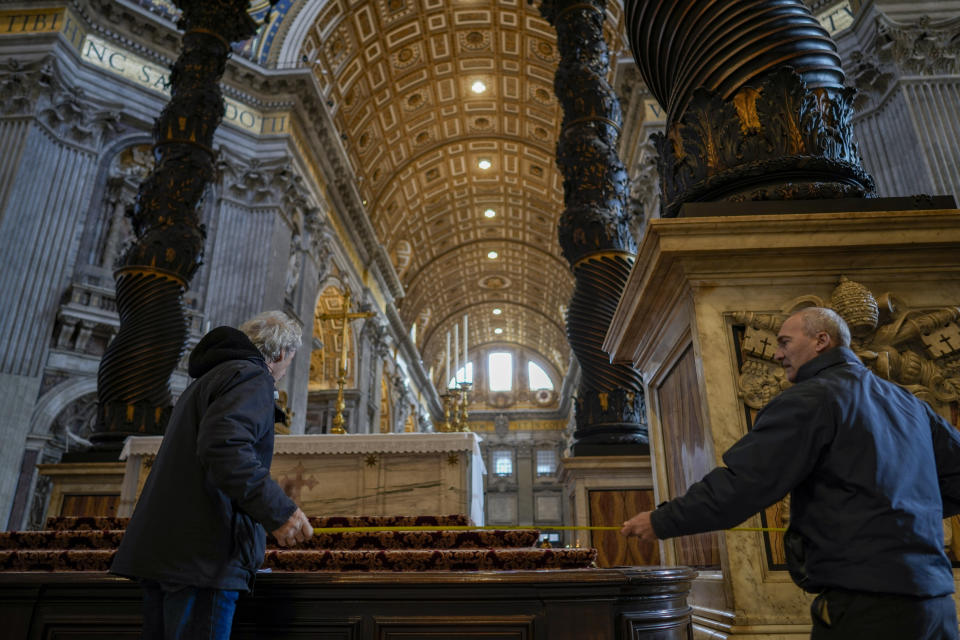Workmen take measurements at the base of the 17th century, 95ft-tall bronze canopy by Giovan Lorenzo Bernini surmounting the papal Altar of the Confession in St. Peter's Basilica at the Vatican, Wednesday, Jan. 10, 2024. Vatican officials unveiled plans Thursday, Jan.11, for a year-long, 700,000 euro restoration of the monumental baldacchino, or canopy, of St. Peter's Basilica, pledging to complete the first comprehensive work on Bernini's masterpiece in 250 years before Pope Francis' big 2025 Jubilee. (AP Photo/Andrew Medichini)