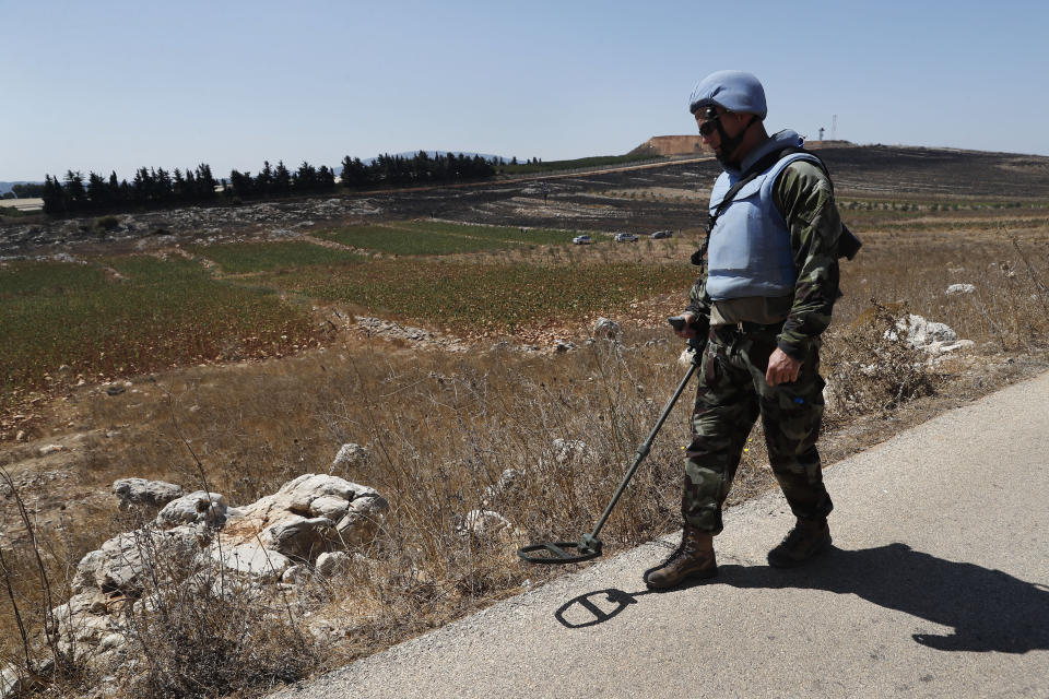 Irish UN peacekeepers use mine detectors as they patrol near the fields struck by Israeli army shells in the southern Lebanese-Israeli border village of Maroun el-Ras, Lebanon, Monday, Sept. 2, 2019. The Lebanon-Israel border was mostly calm with U.N. peacekeepers patrolling the border Monday, a day after the Lebanese militant Hezbollah group fired a barrage of anti-tank missiles into Israel, triggering Israeli artillery fire that lasted less than two hours and caused some fires. (AP Photo/Hussein Malla)