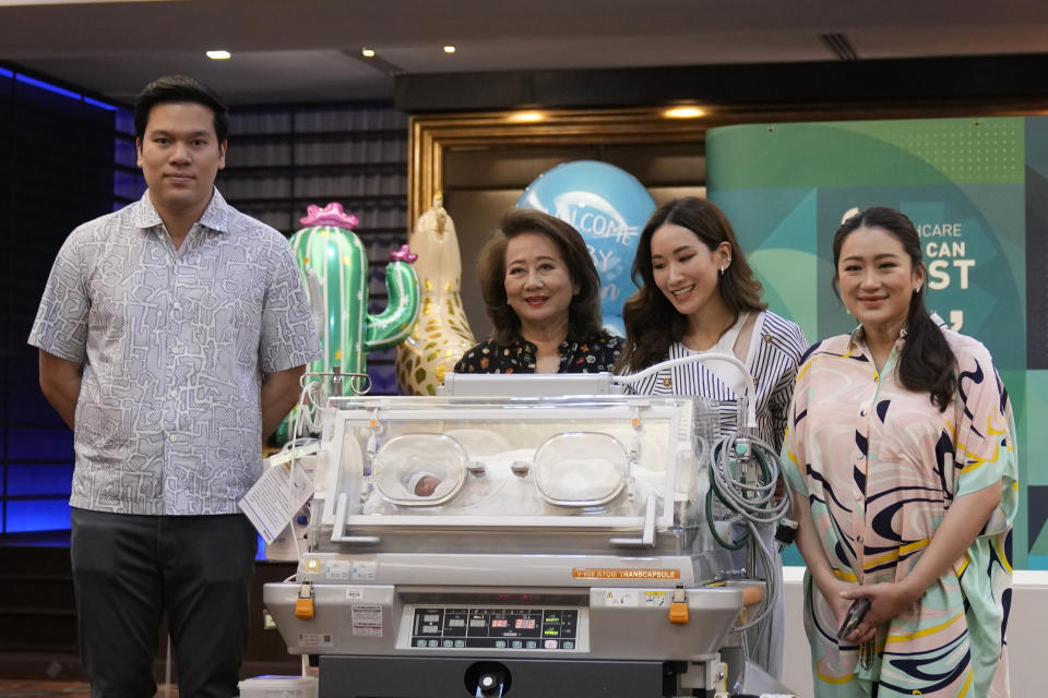 Paetongtarn Shinawatra, right, a leading Thai politician and youngest daughter of exiled former deposed Thai leader Thaksin Shinawatra, stands behind an incubator with her new born son, along with, left to right, her husband Pidok Sooksawas, mother Pojaman Na Pombejra and sister Pinthongta Shinawatra during press conference in Bangkok, Thailand, Wednesday, May 3, 2023. The frontrunning candidate for prime minister of Thailand said Wednesday she’s eager to get back on the campaign trail, just two days after giving birth. (AP Photo/Sakchai Lalit)