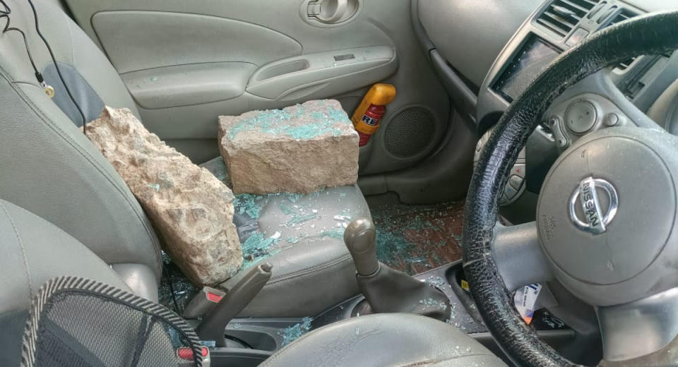 Uber cab driver was allegedly assaulted, image of car being broken into with cylinder rocks breaking the car window