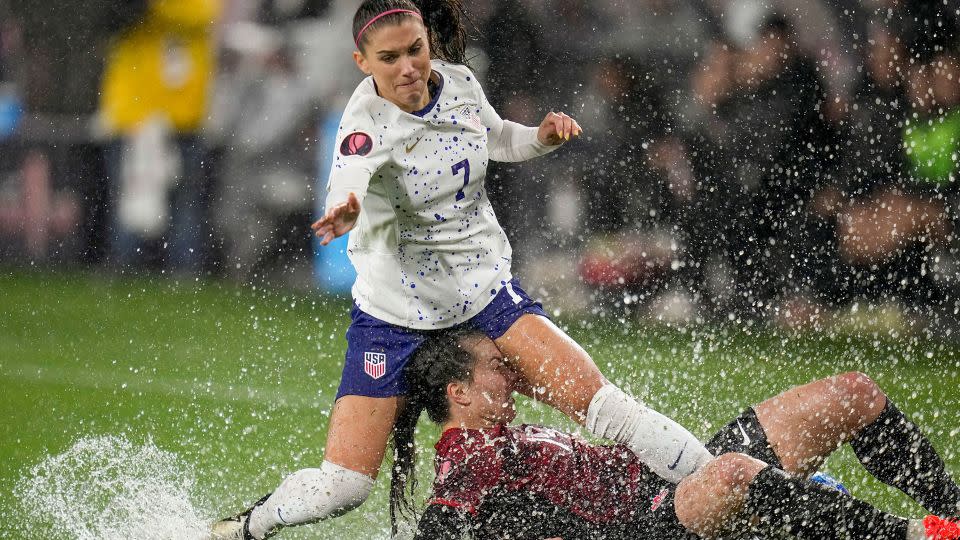 Alex Morgan of the US collides with Canada's Vanessa Gilles. - Gregory Bull/AP