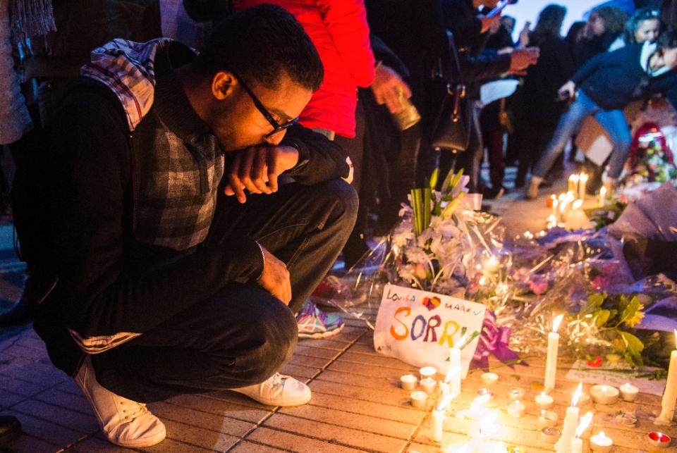 A Moroccan man places a candle during a vigil for the two Scandinavian hikers. Image: AFP