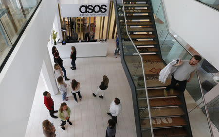 FILE PHOTO: New employees wait in the lobby on their first day of work at the ASOS headquarters in London April 1, 2014. REUTERS/Suzanne Plunkett