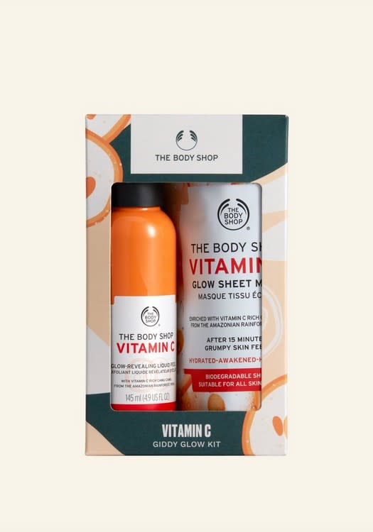 Vitamin C Giddy Glow Kit shown on a cream background in a small green, orange and white box containing an orange bottle and a rolled sheet.