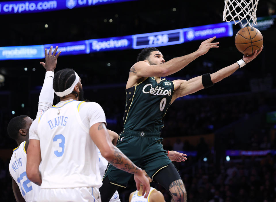 LOS ANGELES, CALIFORNIA - DECEMBER 13: Jayson Tatum #0 of the Boston Celtics cuts to the basket for a layup past Kendrick Nunn #12 and Anthony Davis #3 of the Los Angeles Lakers during the first half at Crypto.com Arena on December 13, 2022 in Los Angeles, California. NOTE TO USER: User expressly acknowledges and agrees that, by downloading and/or using this photograph, User is consenting to the terms and conditions of the Getty Images License Agreement. Mandatory Copyright Notice: Copyright 2022 NBAE. (Photo by Harry How/Getty Images)