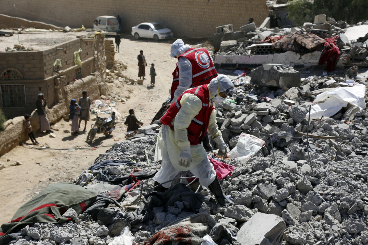 Rescue members search for victims among rubble in Yemen.