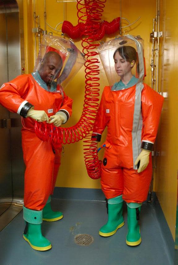 Centers for Disease Control microbiologists are shown in this 2007 photo in the process of suiting up to access the interior of the organization's Biosafety Level-4 (BSL-4) laboratory.