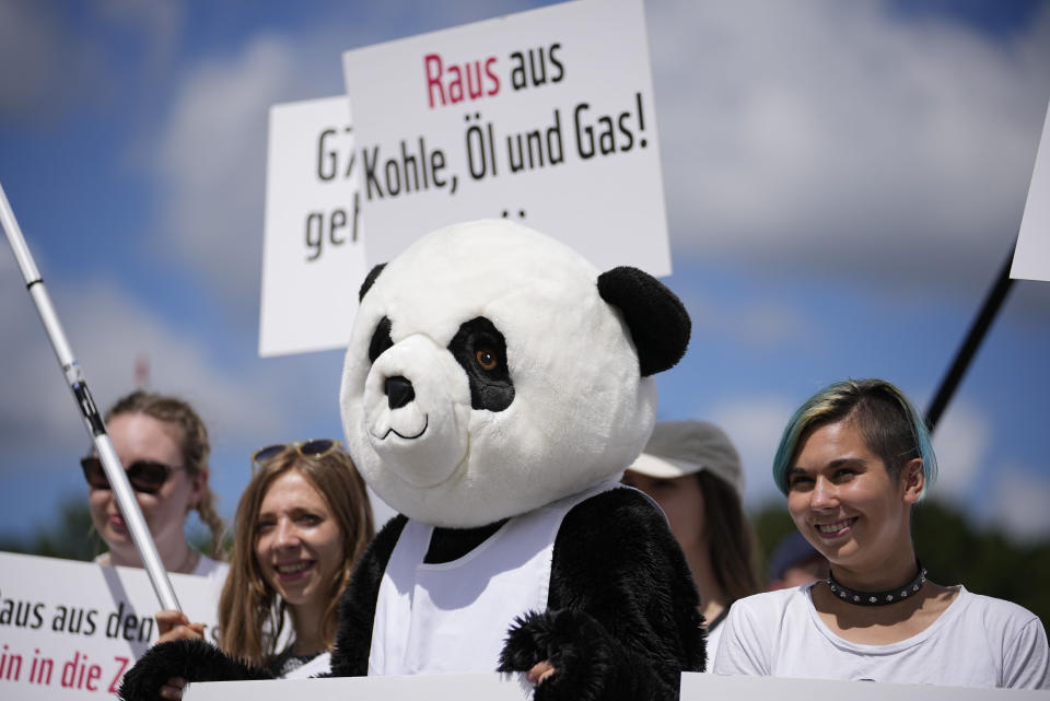 A protestor dressed as a panda bear holds a sign which reads 'out of coal, oil and gas' during a demonstration ahead of the G7 meeting in Munich, Germany, Saturday, June 25, 2022. The G7 Summit will take place at Castle Elmau near Garmisch-Partenkirchen from June 26 through June 28, 2022. (AP Photo/Martin Meissner)