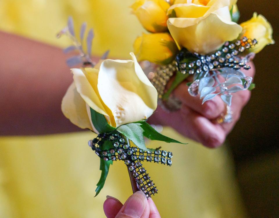 Charon Thompson shows the prom corsage and boutonniere Saturday, May 13, 2023, of her son, Cade, and his date to Avon High School's prom, Vivian Eagle. Both Cade and Eagle had and beat osteosarcoma, a cancer of the bone. The cancer ribbon color of osteosarcoma is yellow.