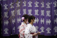 Visitors wear protective masks Wednesday, Feb. 26, 2020, in Tokyo. At a government task force meeting Wednesday on the virus outbreak, Japan's Prime Minister Abe said he was asking organizers to cancel or postpone major sports or cultural events over the next two weeks. (AP Photo/Eugene Hoshiko)