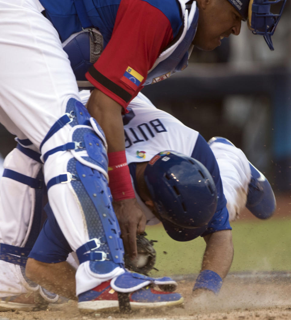 Italy's Drew Butera collides with Venezuela's Salvador Perez during a World Baseball Classic game in Guadalajara, Mexico, Saturday, March 11, 2017. All-Star catcher Perez injured his left knee in a home-plate collision with his Kansas City Royals backup Drew Butera in a World Baseball Classic game. Venezuela rallied to beat Italy 11-10 on Martin Prado's 10th-inning double after Butera stumbled into Perez to end the ninth with the score tied at 10.(AP Photo/Luis Gutierrez)