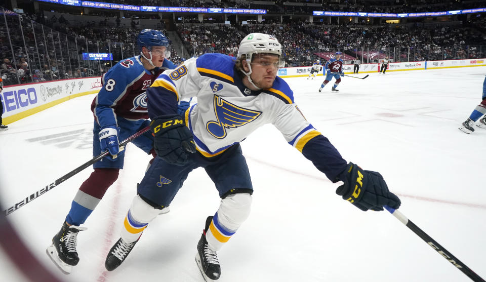 St. Louis Blues center Robert Thomas, right, reaches out for the puck as Colorado Avalanche defenseman Cale Makar pursues in the first period of Game 1 of an NHL hockey Stanley Cup first-round playoff series Monday, May 17, 2021, in Denver. (AP Photo/David Zalubowski)