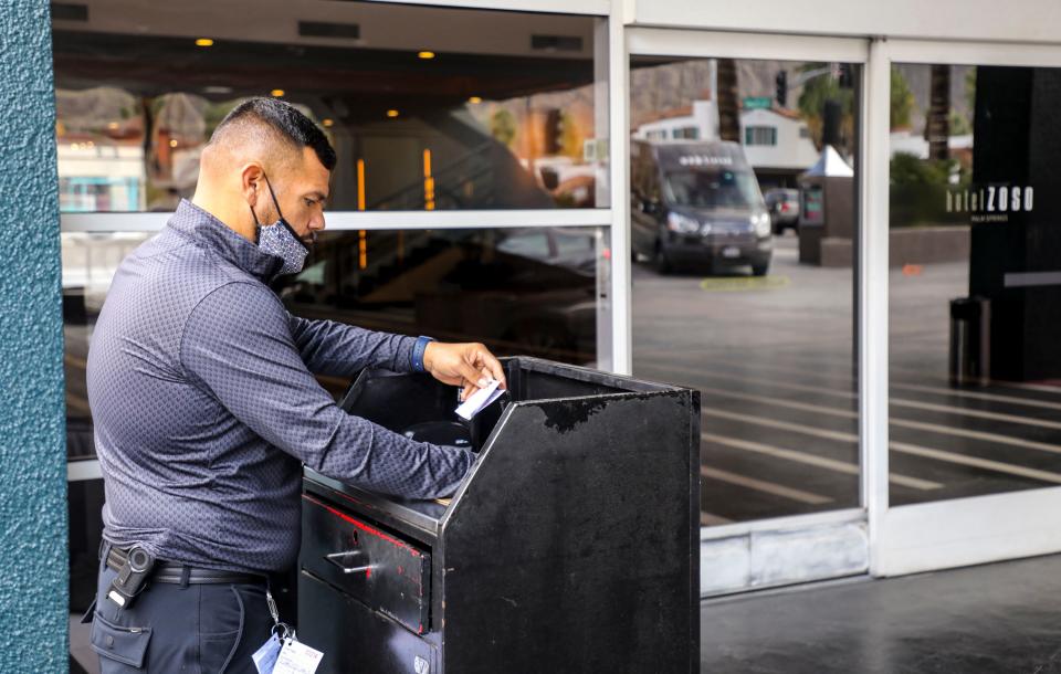 Valet Randy Perea fills out paper work after bringing a car up from parking for two guests at Hotel Zoso, Jan. 13, 2022, in Palm Springs. The hotel has had trouble filling positions such as valets for much of the last year amid a service worker shortage.