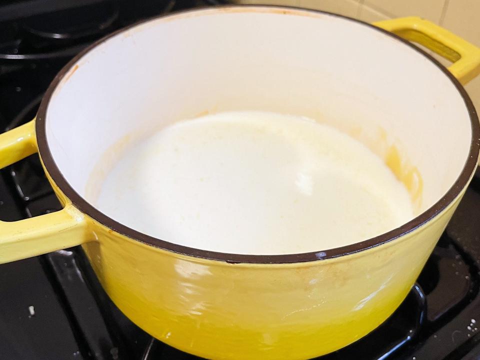 macaroni and cheese sauce in a yellow pot on the stove