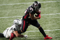 Atlanta Falcons running back Ito Smith (25) runs against Las Vegas Raiders inside linebacker Nick Kwiatkoski (44) during the second half of an NFL football game, Sunday, Nov. 29, 2020, in Atlanta. The Atlanta Falcons won 43-6. (AP Photo/John Bazemore)