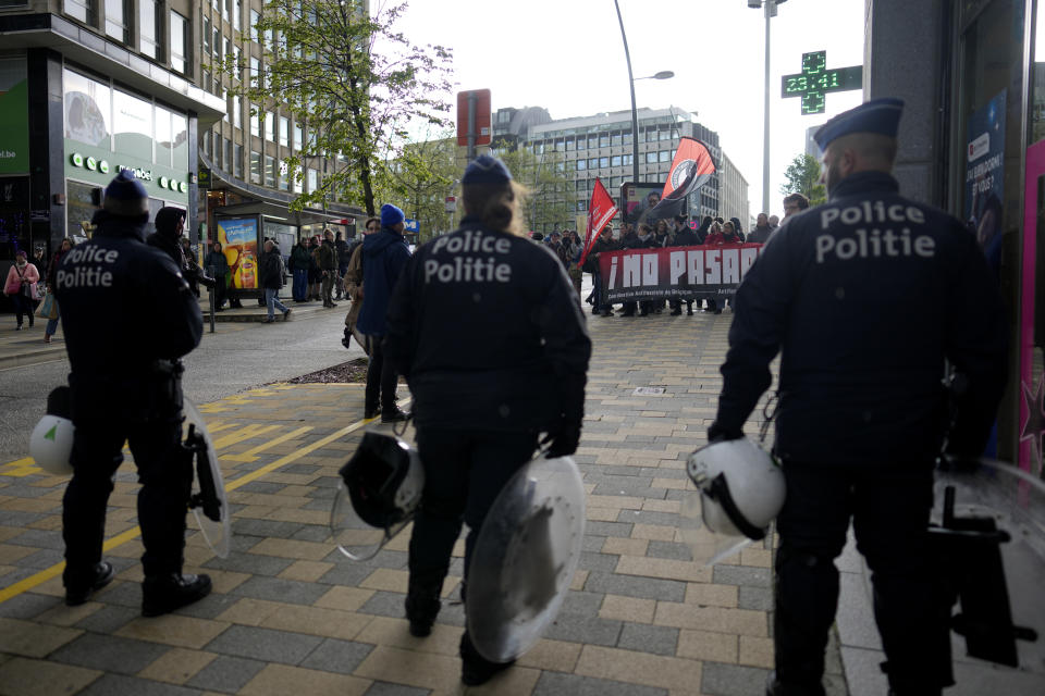 Police look on as demonstrators hold a banner which reads "we shall not let this pass" outside of the National Conservatism conference in Brussels, Tuesday, April 16, 2024. (AP Photo/Virginia Mayo)