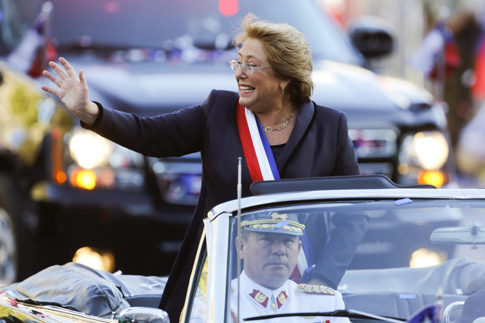 Chile's new President Michelle Bachelet waves from a car heading to La Moneda presidential palace in Santiago, Chile, Tuesday, March 11, 2014. Bachelet, who led Chile from 2006-2010, was sworn-in as president on Tuesday. (AP Photo/Victor R. Caivano)