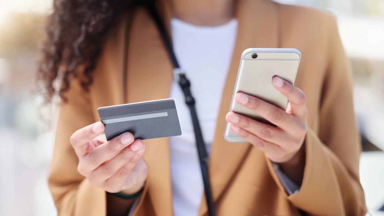woman holding smartphone and gift card