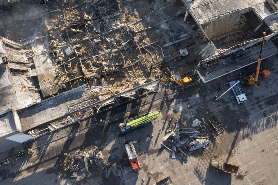 Ukrainian State Emergency Service firefighters work to take away debris at a shopping mall burned after a missile strike in Kremenchuk, Ukraine, Tuesday, June 28, 2022. (AP Photo/Efrem Lukatsky)